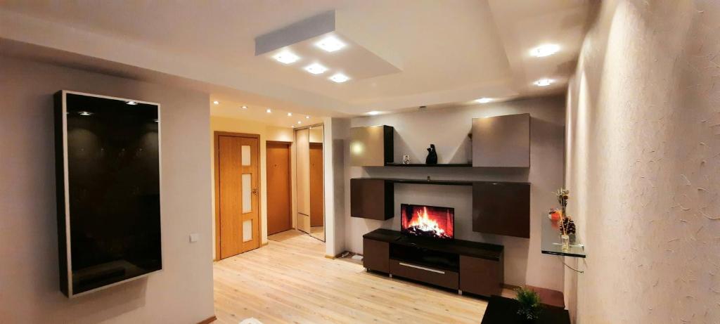 ein Wohnzimmer mit einem Kamin und einem TV in der Unterkunft M&M Apartment VIII Self CHECK-IN in Panevėžys