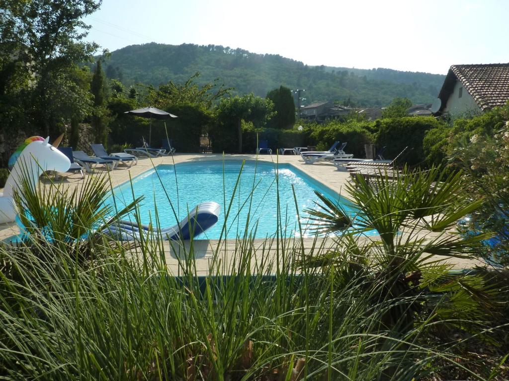 CourryにあるCottage around a swimming pool in a small villaの大きなスイミングプール(ラウンジチェア、木付)
