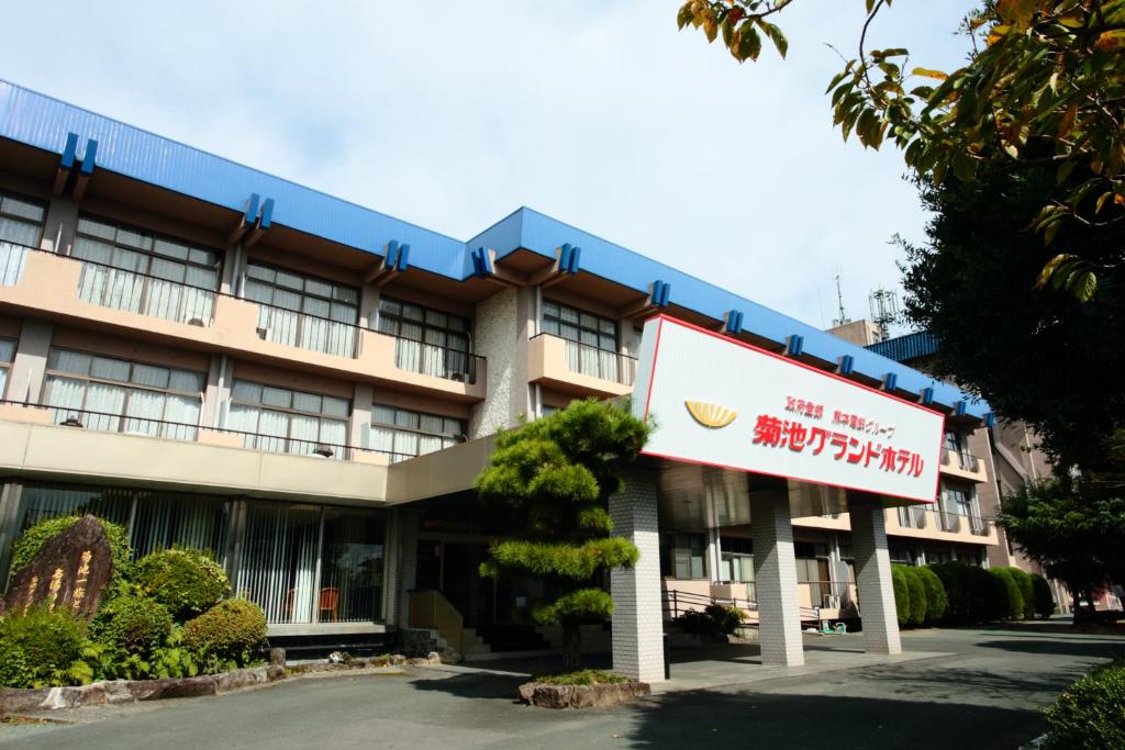 a building with a sign in front of it at Kikuchi Grand Hotel in Kikuchi