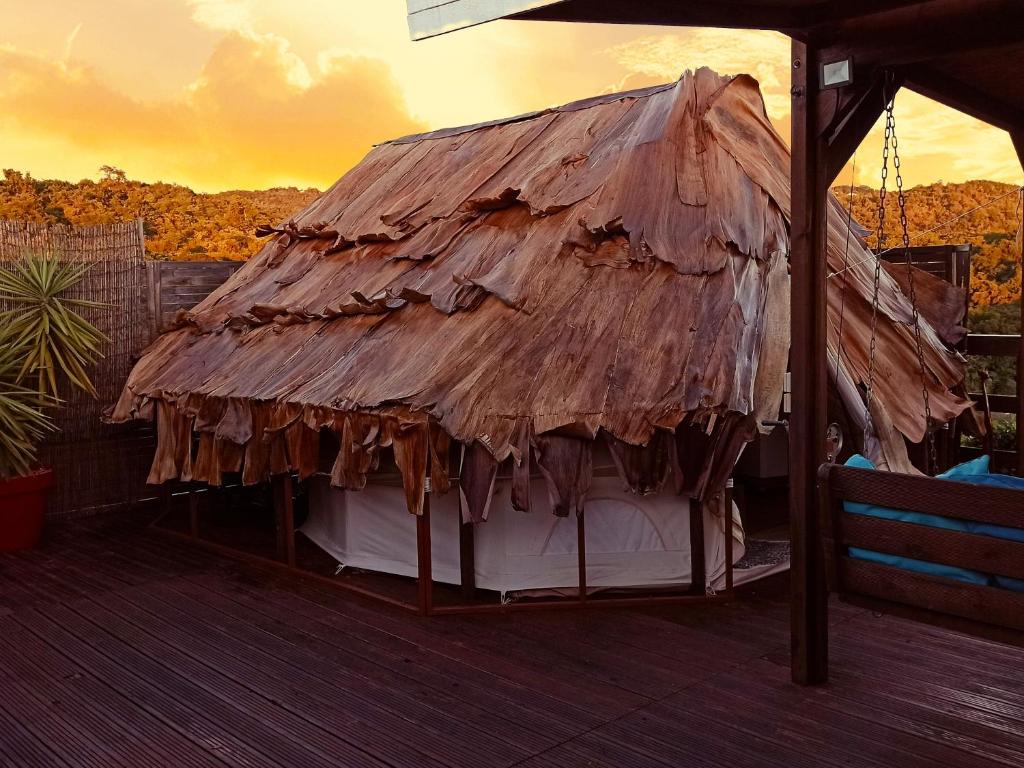 a thatch roof on top of a deck at Kawaida - Hébergement insolite - Glamping Makazi in Sainte-Luce