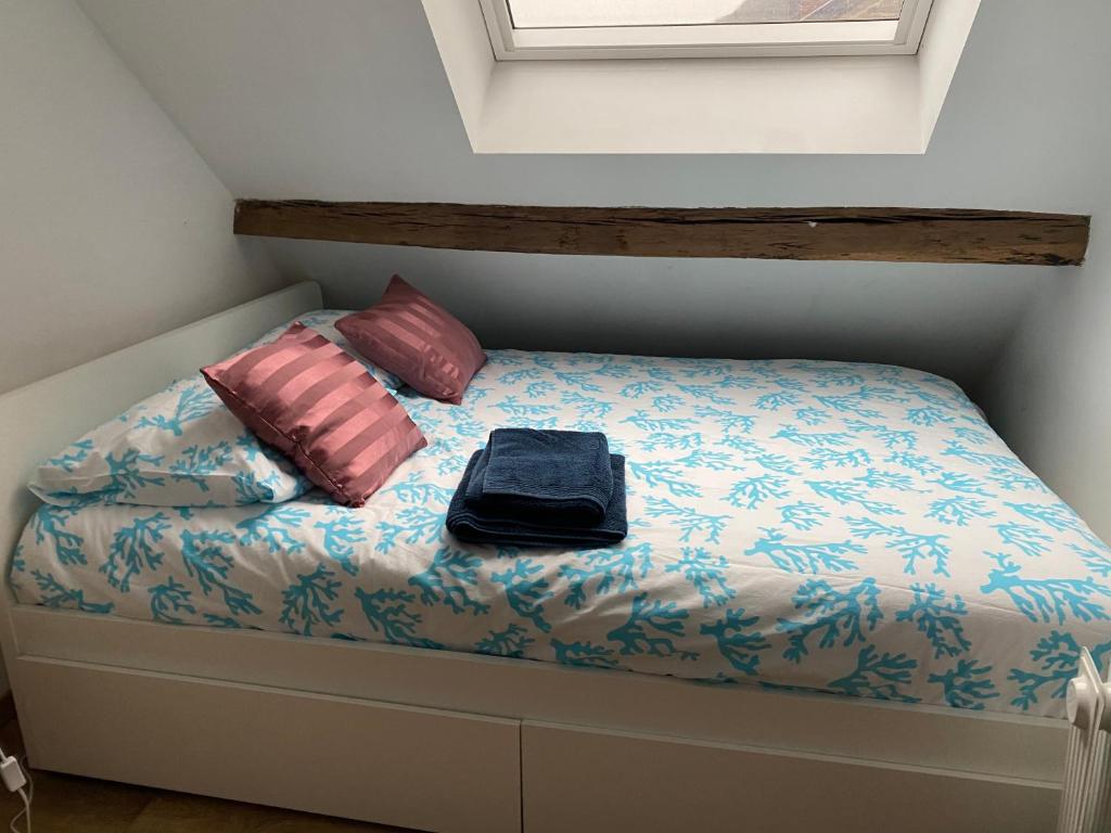 uma cama com duas almofadas e um saco em Gwladys's Home em Aywaille