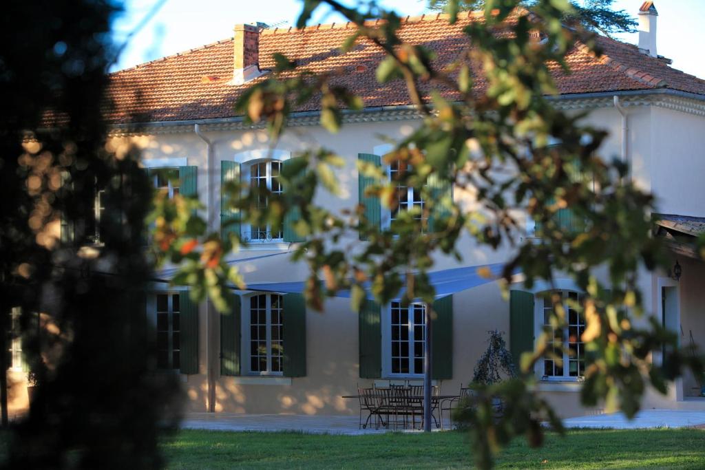 a white house with green shutters at La Maison R in Pignans