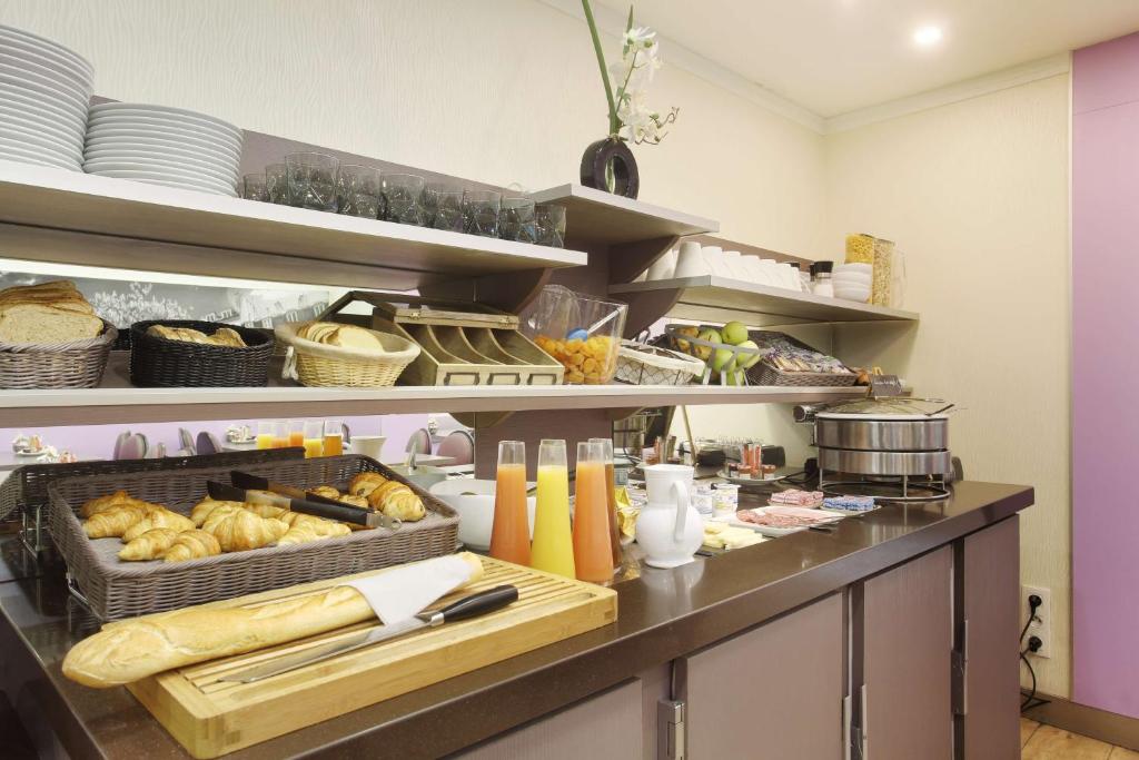 a counter with a variety of food items on it at Hotel Apolonia Paris Mouffetard, Sure Hotel Collection by Best Western in Paris