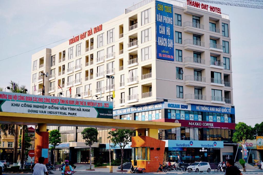 duży biały budynek z znakami w obiekcie Thanh Dat Hotel I w mieście Ninh Lão