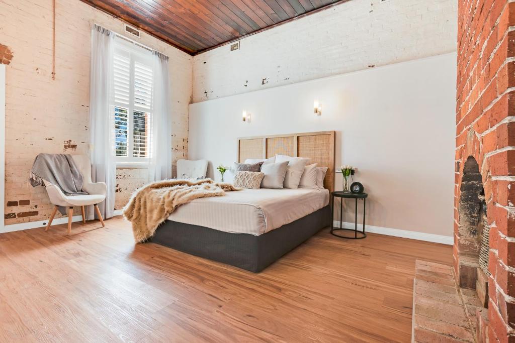 a bedroom with a bed and a brick wall at Perricoota Station in Moama