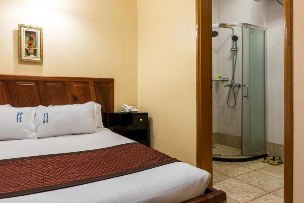ein Schlafzimmer mit einem Bett und einer Dusche in der Unterkunft Luxury apartment for 24 people in Kampala