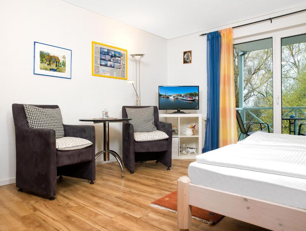 1 dormitorio con 1 cama, 2 sillas y escritorio en Mann un Fru - Residenz am Yachthafen, en Kirchdorf