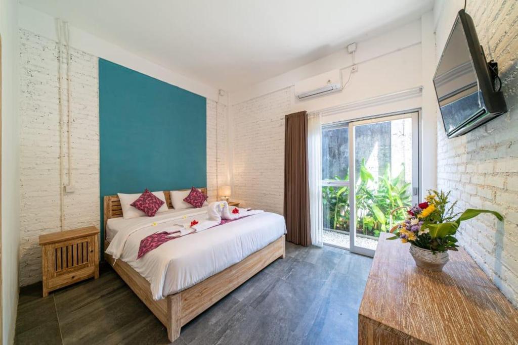 a bedroom with a large bed and a large window at EUFORIA Guest House in Canggu