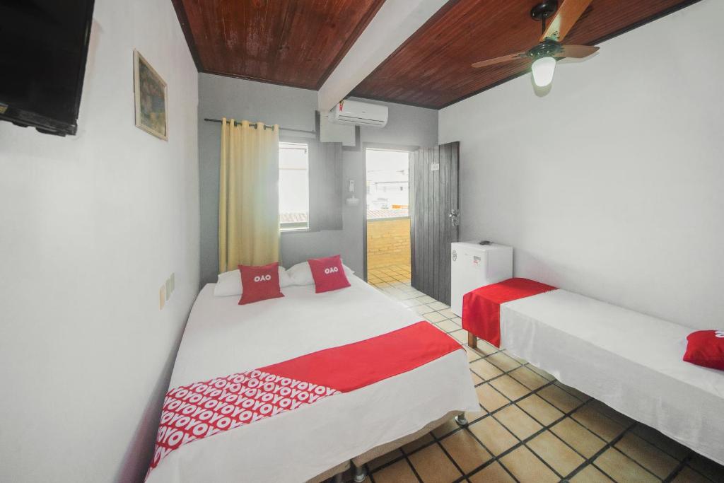 a bedroom with two beds and a ceiling fan at OYO Pousada Do Coco, Porto Seguro in Porto Seguro
