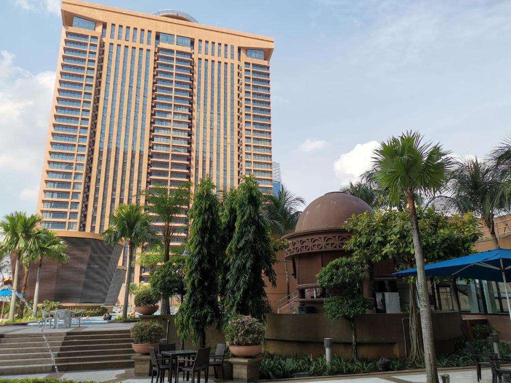 a large building with palm trees in front of it at Elias Suite KL Times Square Bukit Bintang in Kuala Lumpur