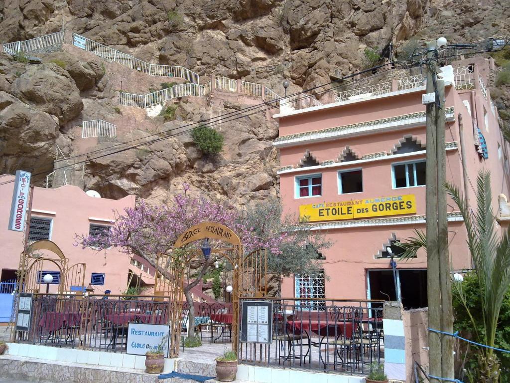 a pink building in front of a mountain at Etoile des Gorges in Aït Baha