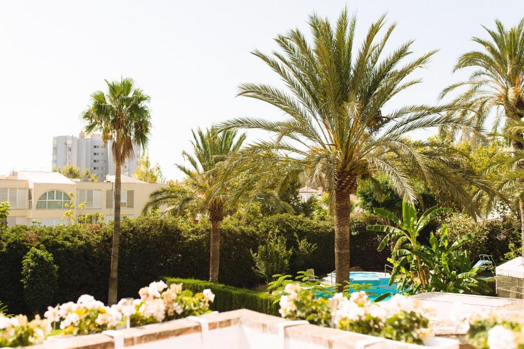 vistas a un jardín con palmeras y flores en Blonski Guadalmar en Málaga