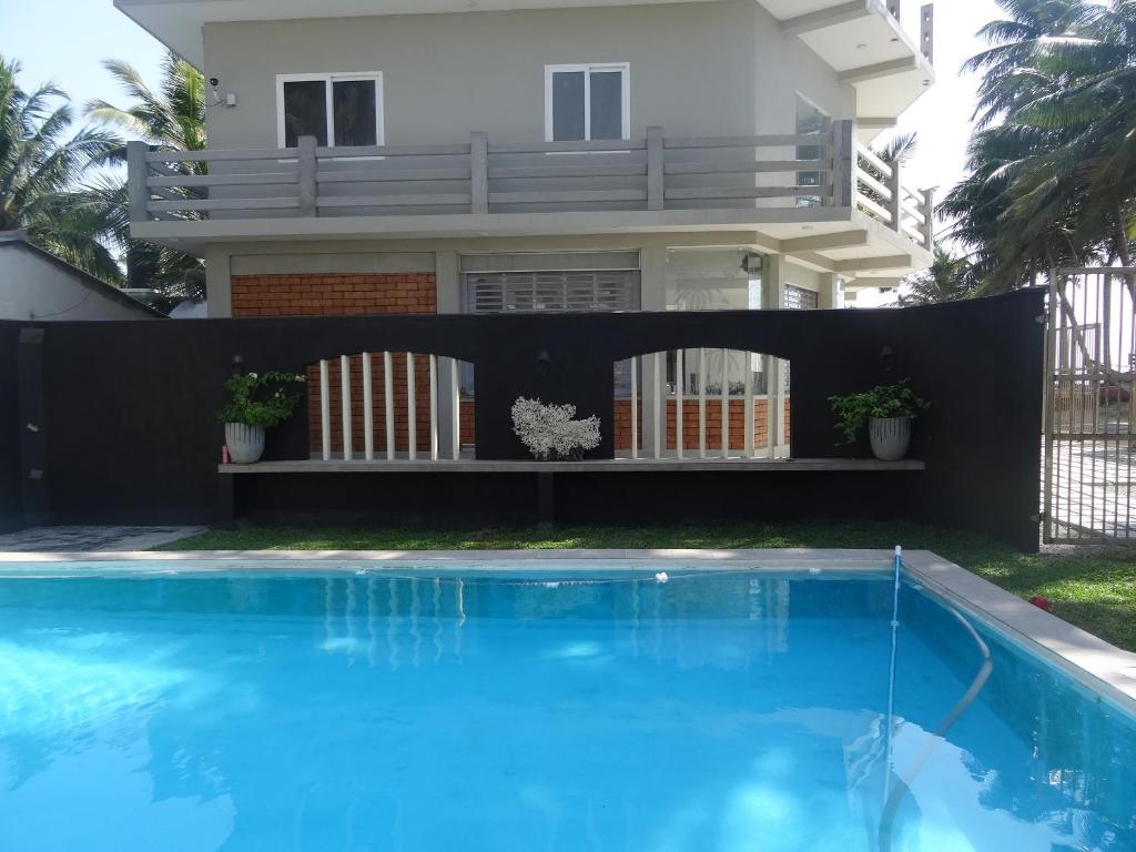 a house with a swimming pool in front of a house at Amssler Beach Stay in Kalutara