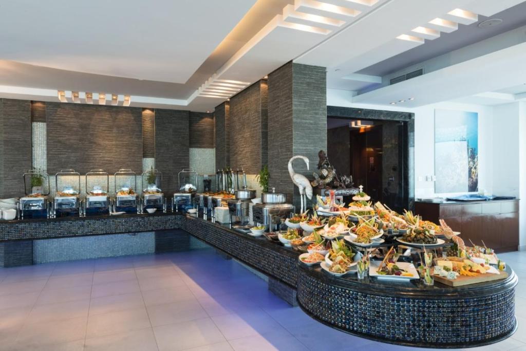 a buffet in a hotel with food on a table at Costa Del Sol Hotel by Arabian Link in Kuwait