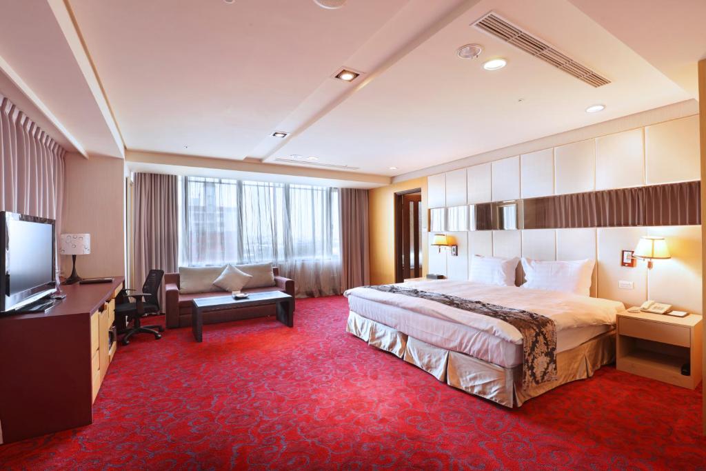 a hotel room with a large bed and a desk at Maison de Chine Chao Yin Building in Taichung
