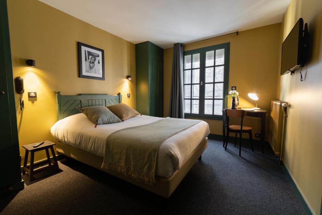 a bedroom with a bed and a desk and a window at Hôtel Saint-Julien in Angers