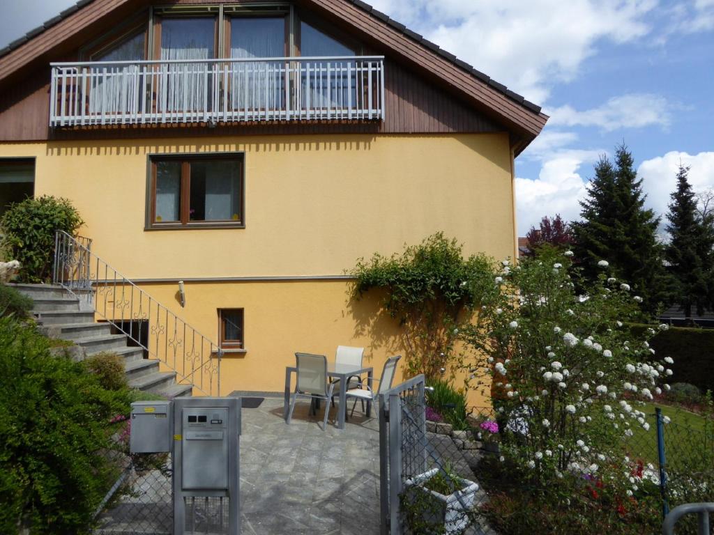 a house with a balcony and a table and chairs at Appartement Ilse Herbert in Würzburg