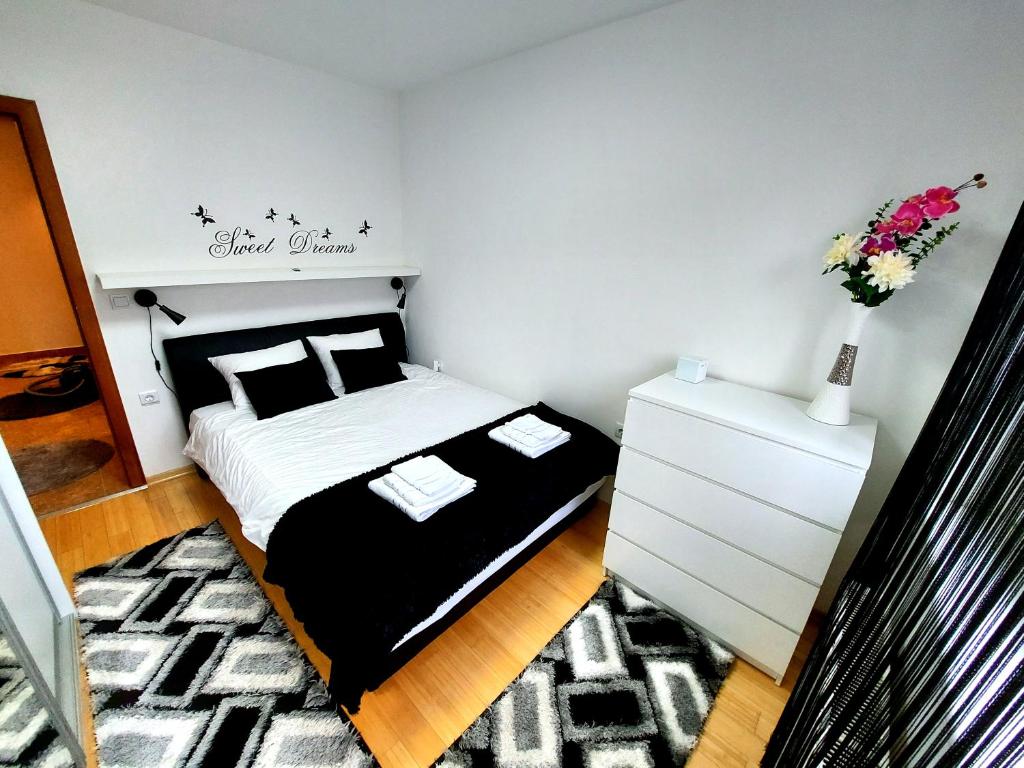a small bedroom with a bed and a white dresser at Deluxe Apartment MyPlace in Osijek