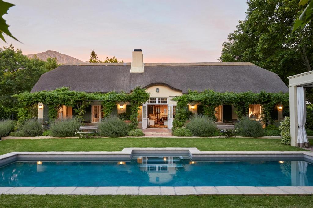 una casa con piscina frente a ella en La Clé Lodge en Franschhoek