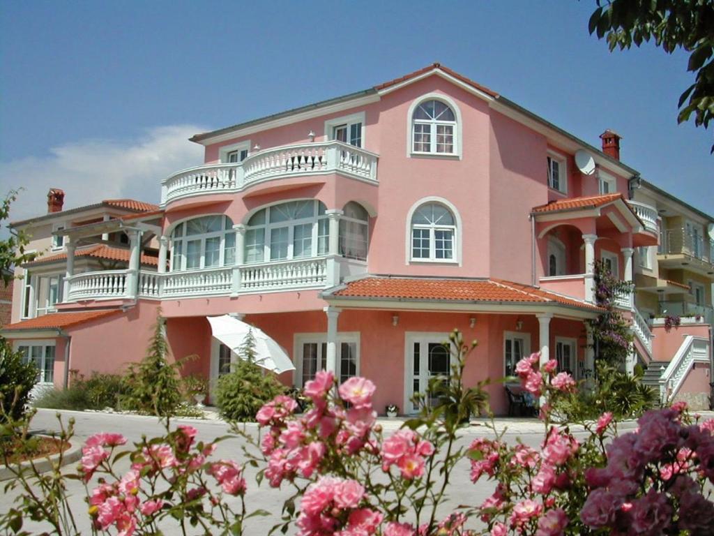 a pink house with flowers in front of it at Hotel Villa Vera in Fažana