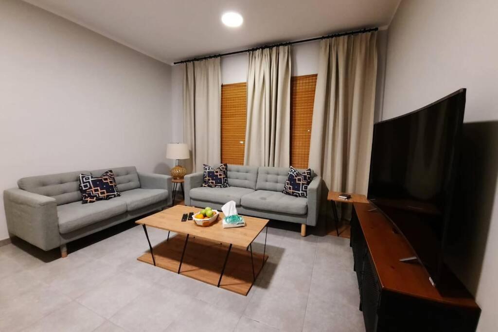 a living room with a couch and a flat screen tv at سن رايز in King Abdullah Economic City