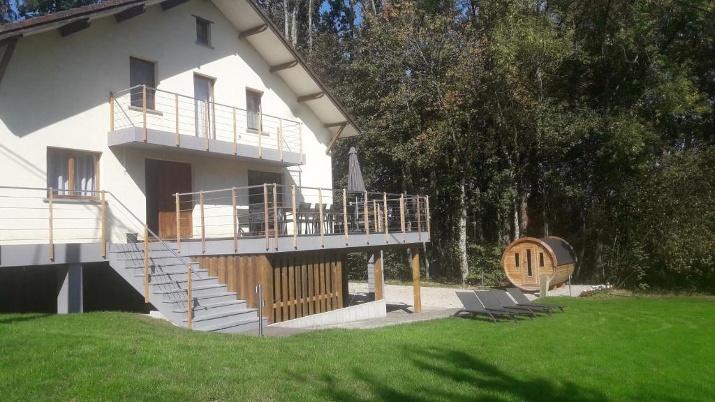 a white house with a deck and a porch at Gîte de la Ferme de Lexhy in Stavelot