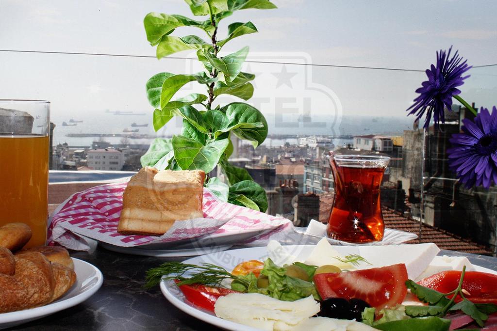 a table with two plates of food and a drink at Sembol Hotel in Istanbul