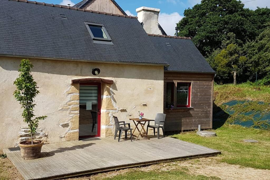 une maison avec une table et des chaises devant elle dans l'établissement Cleuziou Vraz, à Lopérec