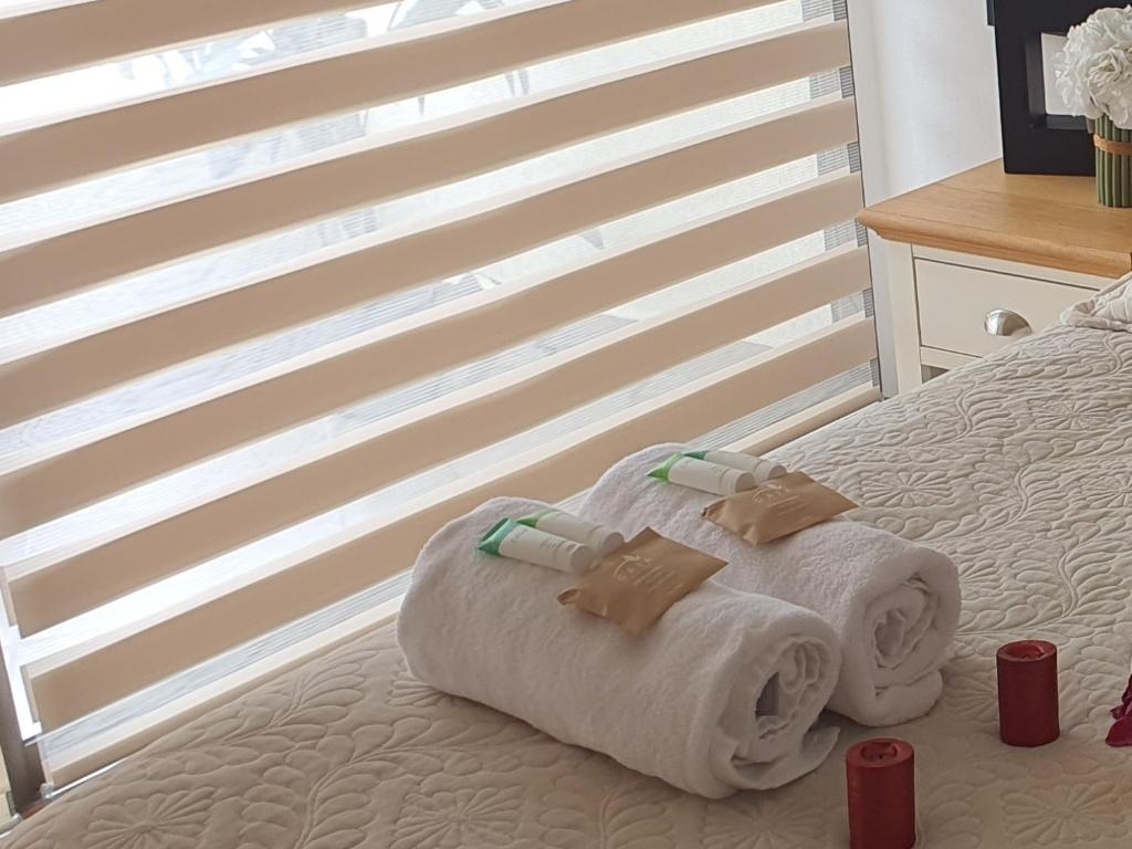 a bed with two towels and two cups on it at MATI´S APARTAMENT in Antofagasta