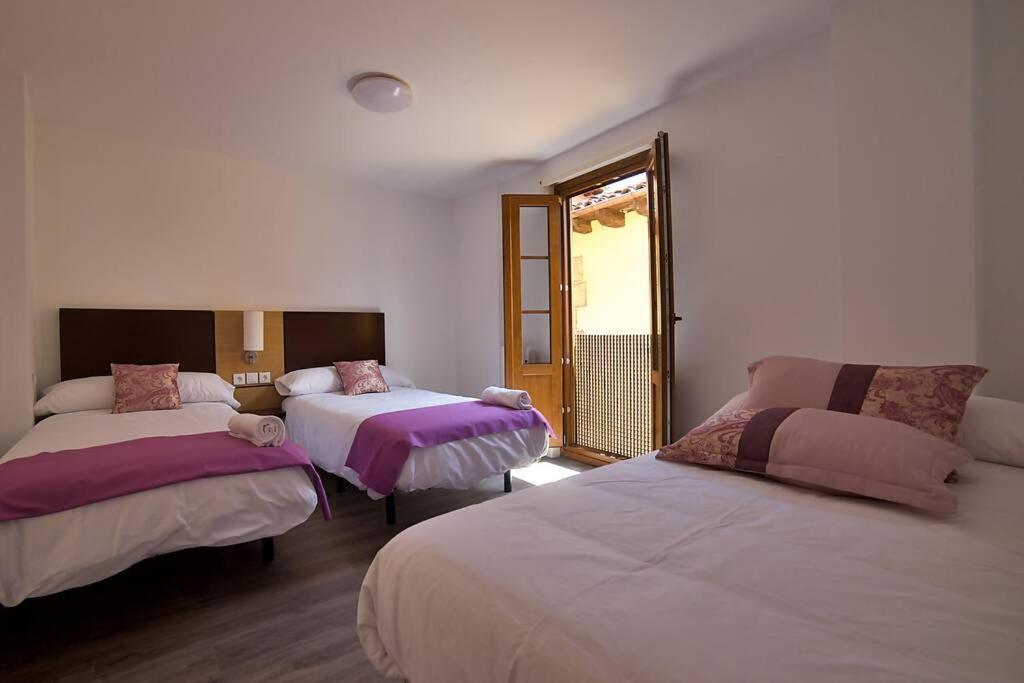 a bedroom with two beds and a window at Alojamientos barrio humedo Plaza Mayor 1 in León