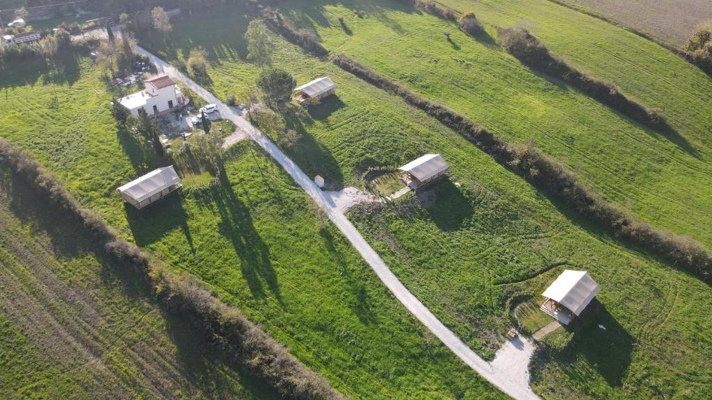 une vue aérienne sur une ferme dans un champ dans l'établissement Glamping Tenuta San Pierino Agriturismo, à Rosignano Marittimo