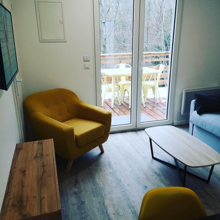 - un salon avec un canapé, une chaise et une table dans l'établissement Les Cottages Barisiens, à Bar-le-Duc