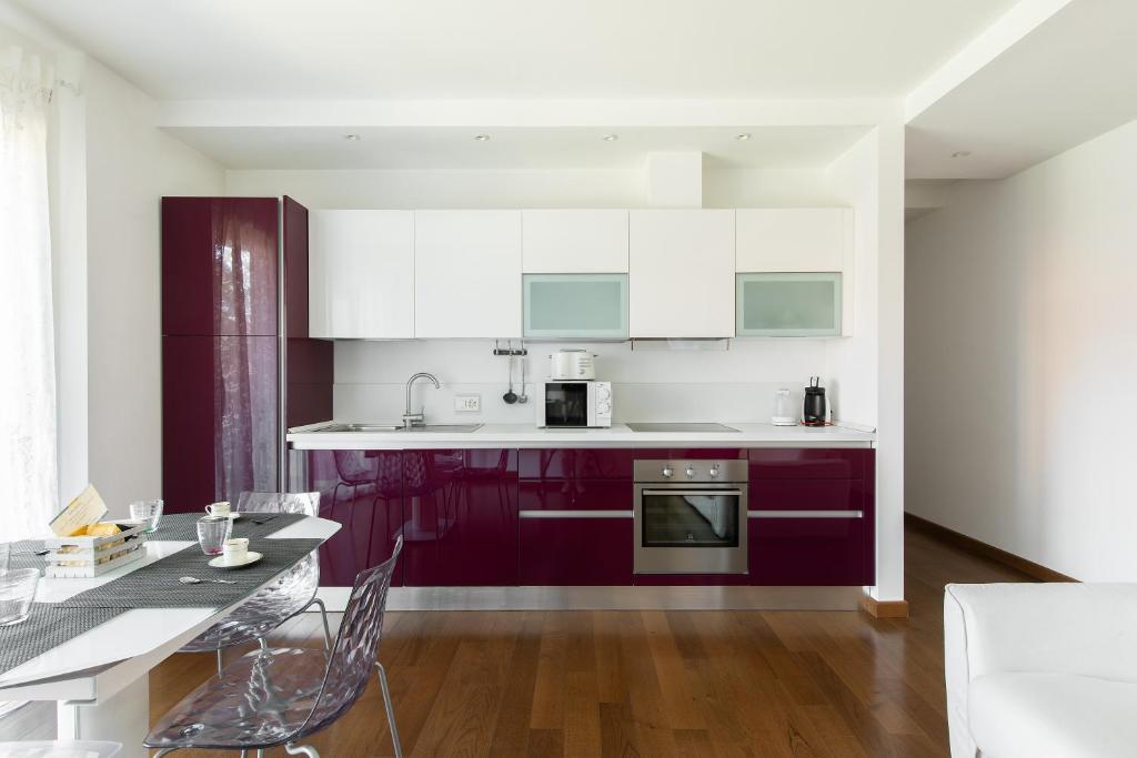 una cocina con armarios morados y blancos y una mesa. en Roggia Apartments by Quokka 360 - central flats with parking space, en Lugano