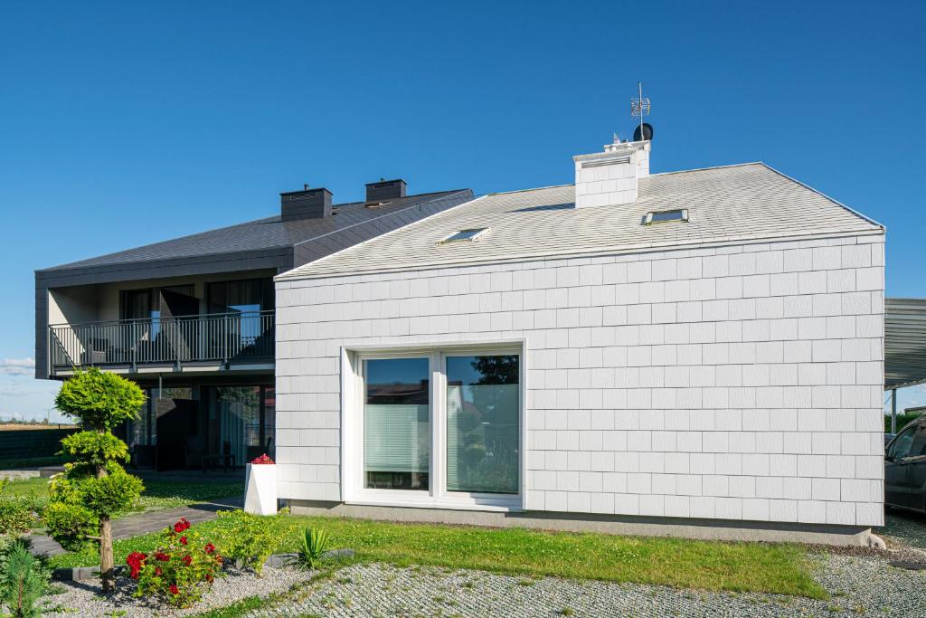 a white brick house with a gray roof at Spokojne Wczasy in Mielno