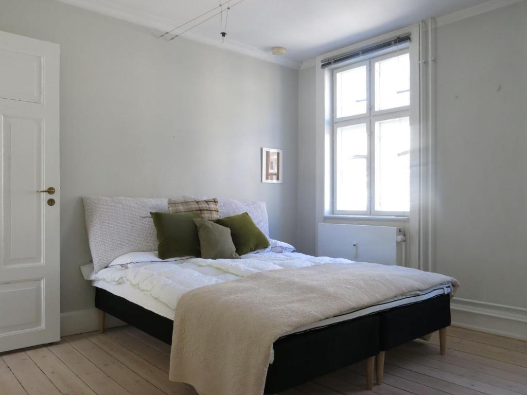 uma cama num quarto branco com uma janela em ApartmentInCopenhagen Apartment 1143 em Copenhague