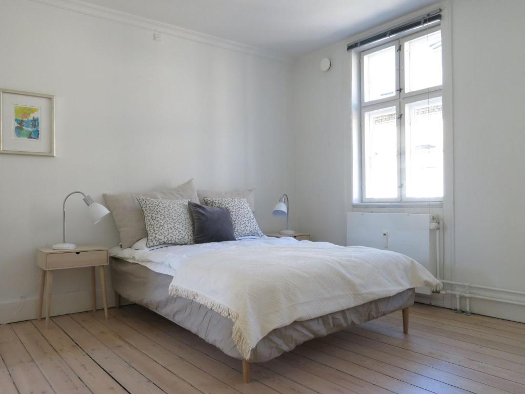 a white bedroom with a bed and a window at ApartmentInCopenhagen Apartment 1144 in Copenhagen