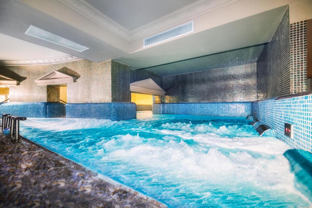 a jacuzzi tub in a hotel with water at Salles Hotels Marina Portals in Portals Nous