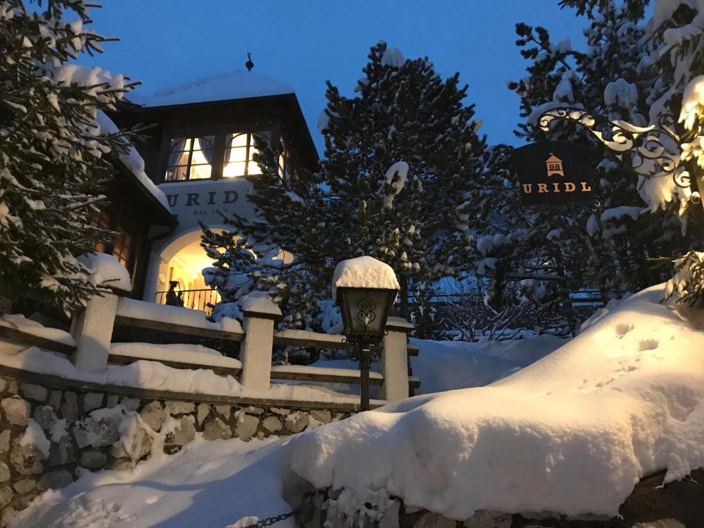 una casa cubierta de nieve por la noche en Charme Hotel Uridl en Santa Cristina in Val Gardena