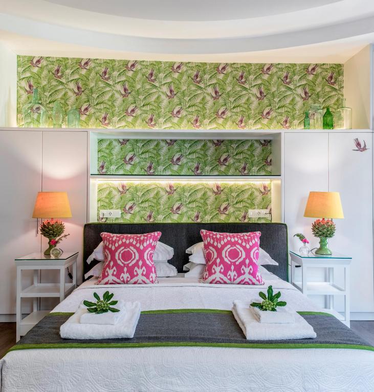 a bedroom with a large bed with pink pillows at Kouloura Liston Suite in Corfu