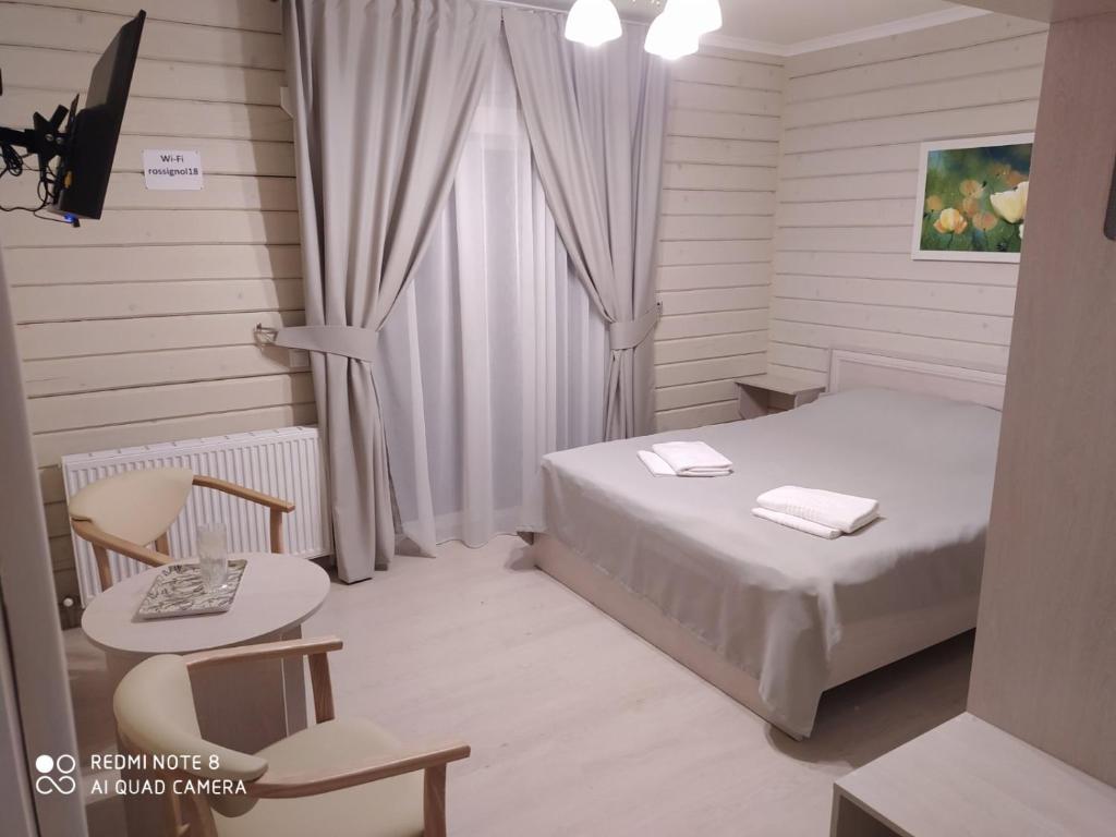 1 dormitorio con cama, mesa y ventana en Pogar White, en Slavske