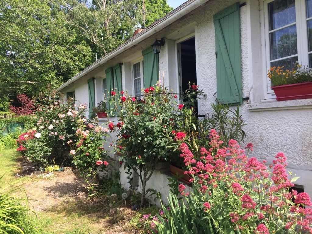 ein Haus mit Blumen vor einem Fenster in der Unterkunft chambres d'hôtes du puy blanc in Saint-Paul