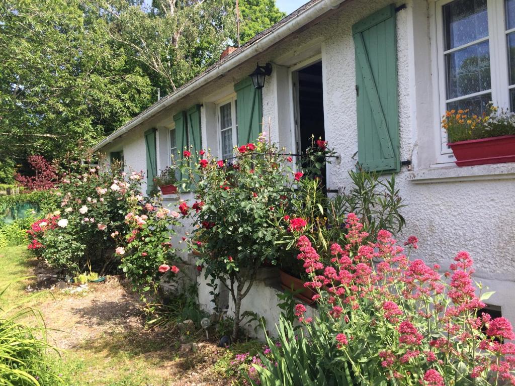 une maison avec des fleurs devant une fenêtre dans l'établissement chambres d'hôtes du puy blanc, à Saint-Paul