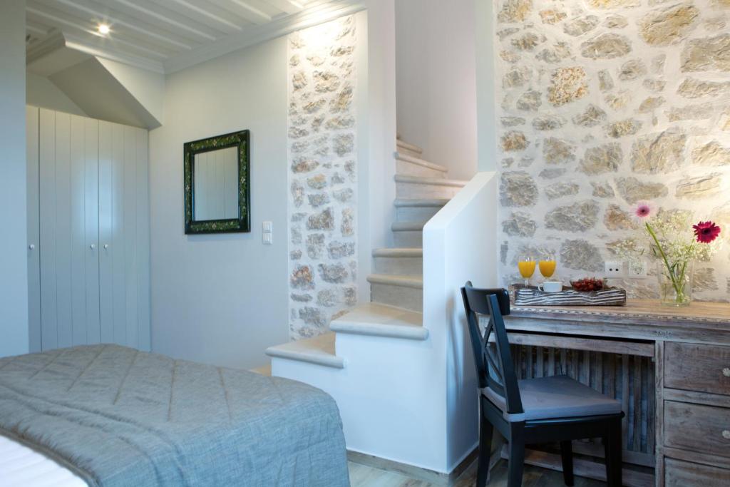 a bedroom with a bed and a desk with a chair at Acquaterra Villas in Tsoukaladhes
