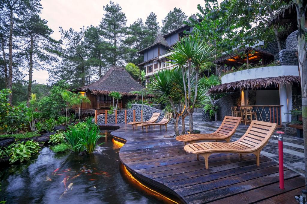 une terrasse en bois avec des chaises et un étang de carpes koï dans l'établissement Tira Vilagna Suites & Spa, à Kintamani