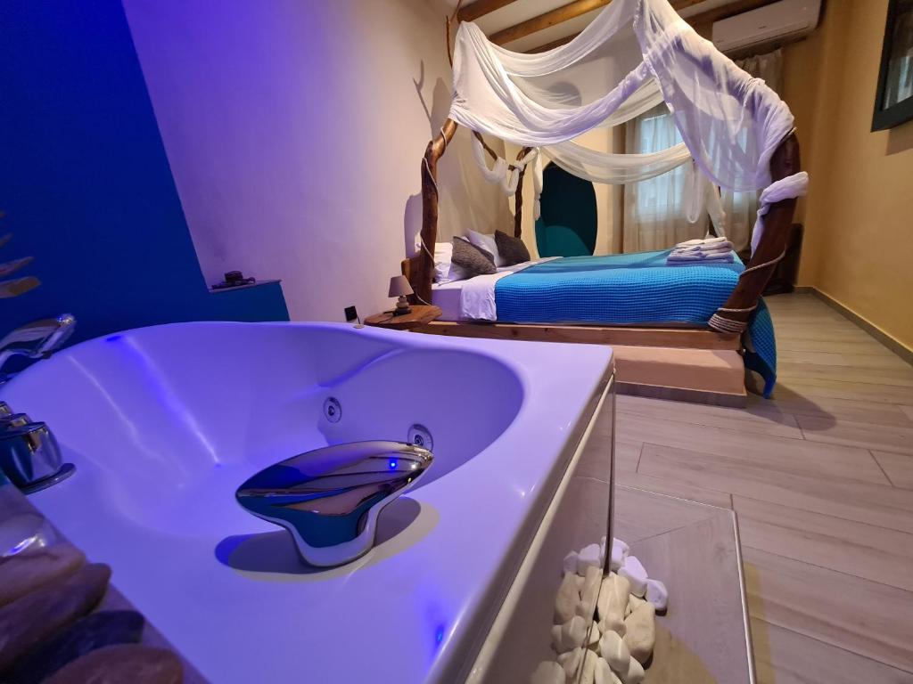 a bathroom with a bath tub with a bed at ThessPalace in Thessaloniki