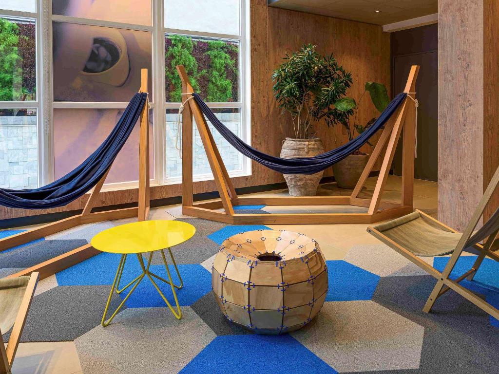 a room with two hammocks and a chair and a table at ibis Sao Paulo Tatuape in Sao Paulo