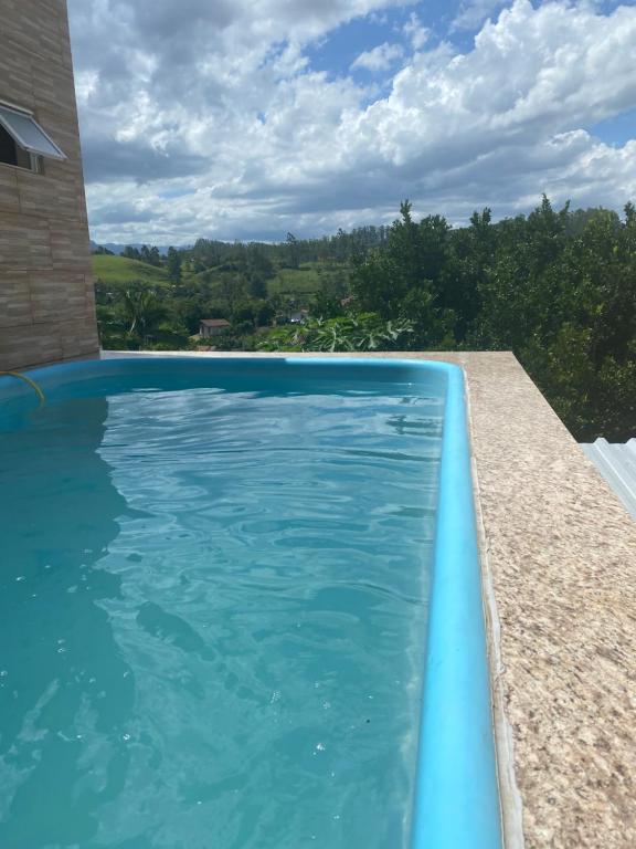 una piscina de agua azul frente a una casa en Bell vale, en Lauro Müller