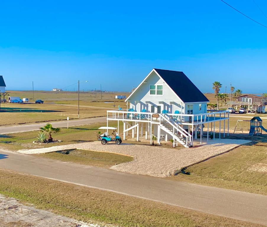 a house on the side of a road with a playground at Salty Poodle Cottage in Freeport