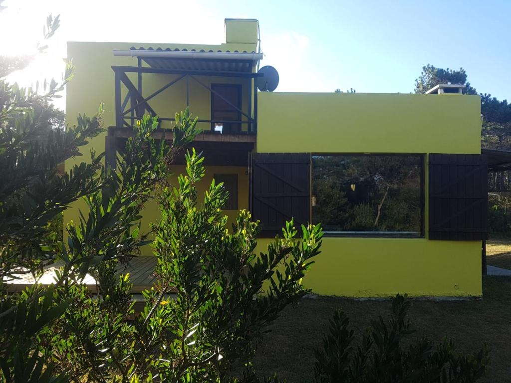 a house with a yellow and green facade at Riyadh - en el bosque a metros de la playa in Rincón de los Oliveras