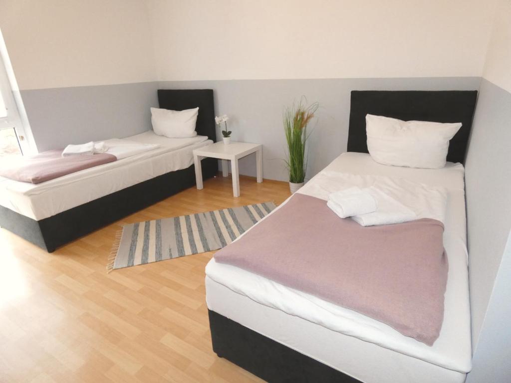 Habitación con 2 camas y mesa. en SUNNYHOME Monteurwohnungen und Apartments in Schwandorf, en Schwandorf